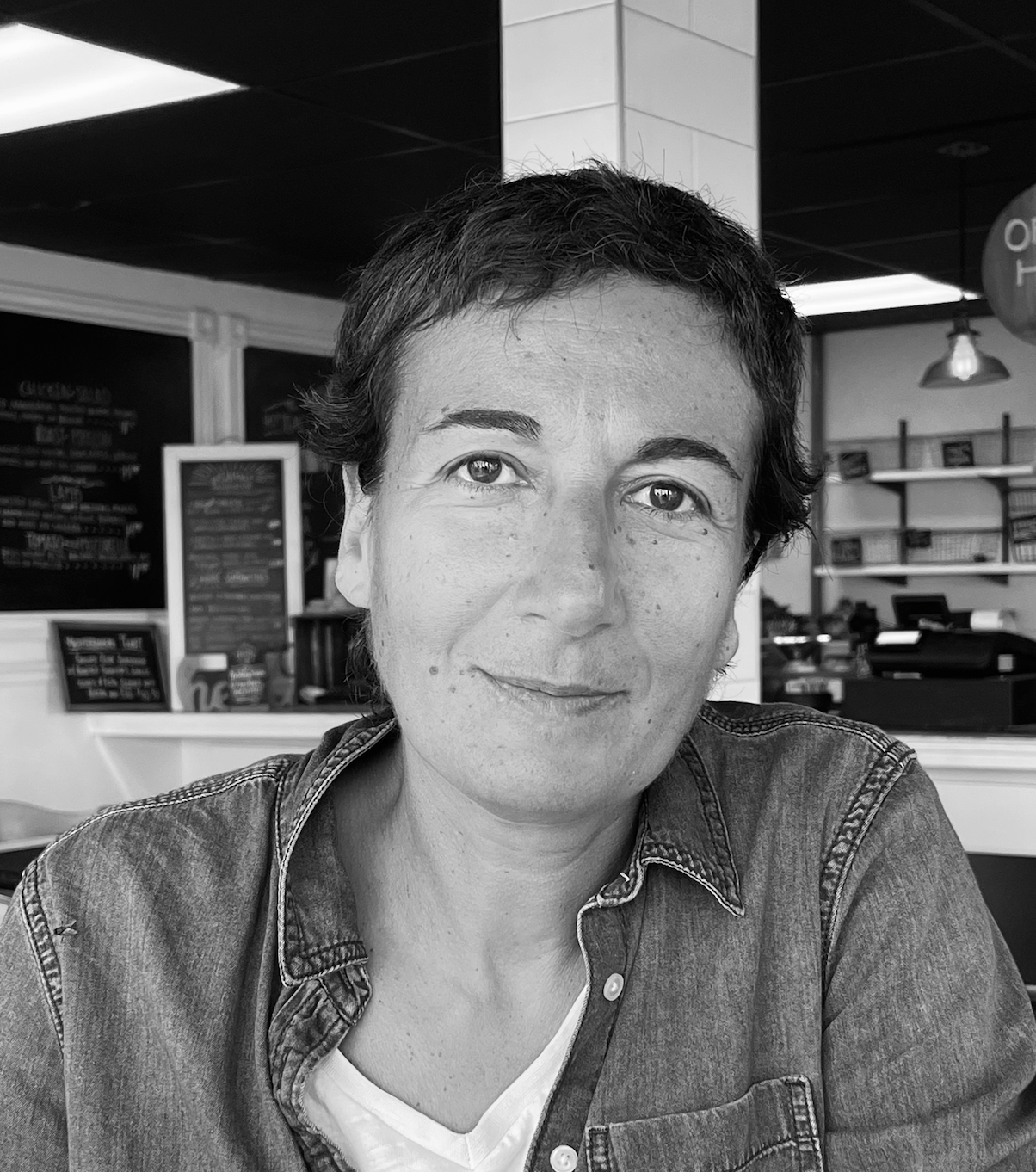 a woman sitting, smiling at the camera